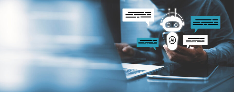 AI Chatbot and Digital Communication Concept, A conceptual image showing artificial intelligence chatbot technology with a robot icon and chat bubbles. A person is using a smartphone beside a laptop.