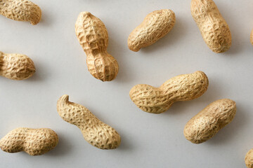 Peanuts in shell showing their shape on a white table.
