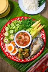 A set of thai cuisine Spicy shrimp paste dip with fried mackerel ,fried egg with climbling wattle,soft boiled eggs and set of vegetables