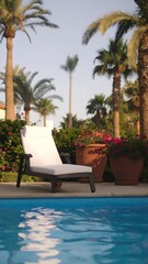 Fototapeta premium Relaxing white sun lounger by a pool, surrounded by lush greenery and palm trees.