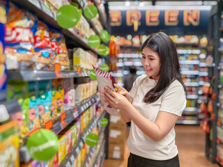 woman is shopping in a grocery store and is looking at a bag of chips
