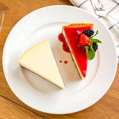 Two slices of creamy cheesecake topped with a vibrant red berry compote, presented on a white plate, showcasing a delightful dessert.
