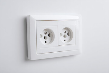 Standard white electrical outlet with dual sockets mounted on a wall. A household power access point symbolizing energy supply, connectivity, and modern infrastructure, isolated on white background.
