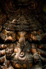 Close-up of traditional wooden carving of Hindu god Ganesha with elephant head, symbol of wisdom, prosperity, and protection in Indian spirituality.
