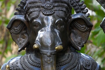 Close-up of traditional wooden carving of Hindu god Ganesha with elephant head, symbol of wisdom, prosperity, and protection in Indian spirituality.