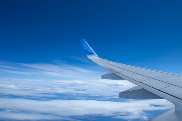 Obraz premium Wing Detail: Passenger Plane Against Blue Sky