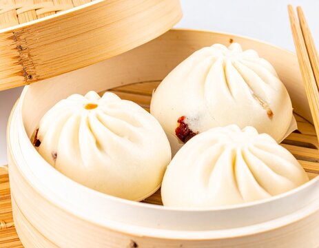 Indonesia Bun Bread Bakpao with Filling Inside Bun  in the Steamed Plate Bamboo with White Background