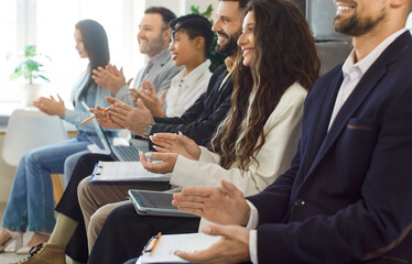 Business audience sitting in row in conference room and applauding, listening presentation and demonstrating appreciation, having training seminar meeting, thanking for good speech