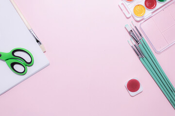 School supplies on a colorful background. Back to school background. Brushes, watercolors, pencils,...
