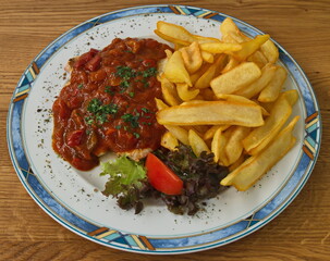 Pork steak with vegetables and pommes frites in Austria,Europe
