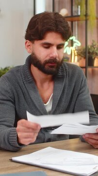 Indian man at home sees unexpected bill feels angry tosses receipt aside no approval gesture at all. Arabian guy at desk checks charges finds extra fee plans dispute calls bank cancels payment quickly