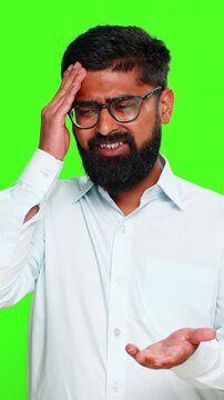 Indian man slaps forehead with hand showing facepalm gesture, expressing regret frustration after clear mistake. Arabian guy isolated on green chroma key background showing emotional realization fail