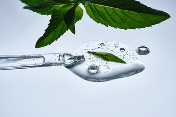 A drop of natural cosmetics with a mint leaf.