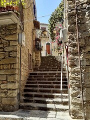 Caratteristico vicolo con scalinata a Centuripe (EN). Muri in pietra, piante e fiori.