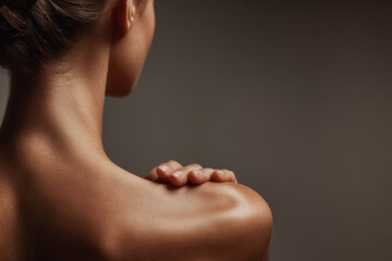 closeup of person back during twisting motion with gray background
