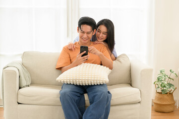 Obraz premium Couple Enjoys Quality Time Together on a Couch While Sharing Smiles and Laughter in a Cozy Living Room