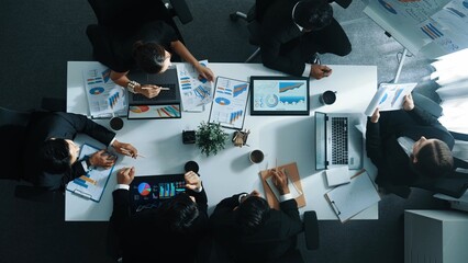 Top down aerial view of investor handed financial document to manager while explain marketing idea at meeting table. People looking at growing graph while listen business team discussion. Directorate. © InfiniteFlow