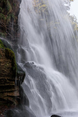 Fototapeta premium Scenic Waterfall in the Swiss Alps, Switzerland. Beautiful waterfall in the Swiss Alps, Switzerland, surrounded by mountains and nature. Scenic alpine landscape with flowing water, rocks, and forest, 
