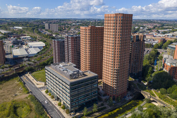 Obraz premium Aerial view of modern high-rise apartments in Leeds, West Yorkshire, with River Aire and railway tracks visible below.