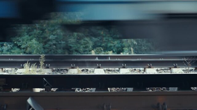 Railway Tracks Close-Up Side View with Train Wheels Rushing Past | Motion Blur Effect on Steel Rails and Sleepers | High Speed Railroad Transportation Detail
