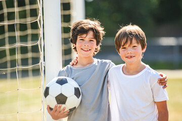 Naklejka premium kids play football or soccer on a outdoor field