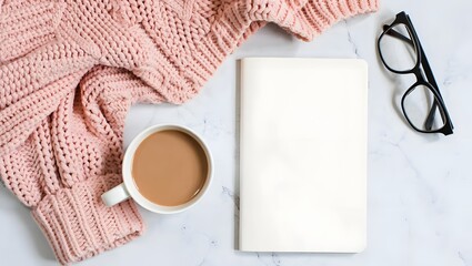 Cozy scene with coffee, book, sweater and glasses on a marble surface, ready for reading