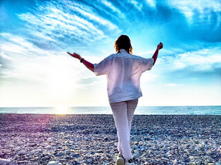 Sunset stroll at the beach with open arms and a sense of freedom
