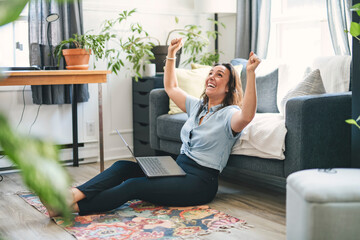 woman sitting surfing the internet on a laptop computer on a sofa at home