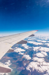 Obraz premium View from the airplane window at a beautiful cloudy sky and the airplane wing