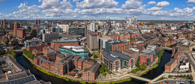 Aerial panorama of Leeds city centre featuring the River Aire, Leeds Dock, and urban skyline in Yorkshire, Northern England.