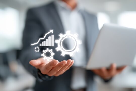 Man is holding a laptop with a graphic of gears and a graph. Concept of progress and growth