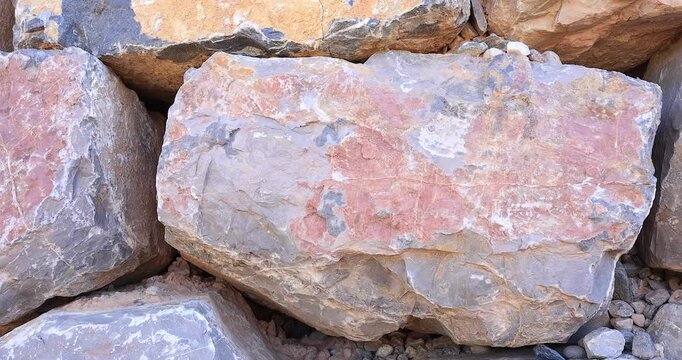 Macro view of multi tan, white and gray color jagged rock in dry stack wall with erosion texture cracks 4k