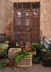 Fresh fruit and vegetables in front of an old door in a street market in The Medina of Marrakesh, Mor