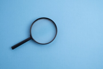 Magnifying glass on a colored background. Conceptual research, enlarging objects. Copy space for text.
