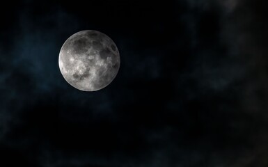 Full moon surrounded by dark clouds in a night sky creating a dramatic scene