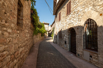 Naklejka premium Beautiful Tuscan historical street and place in the city of Assisi, Tuscany, Italy, Europe. Medieval atmosphere