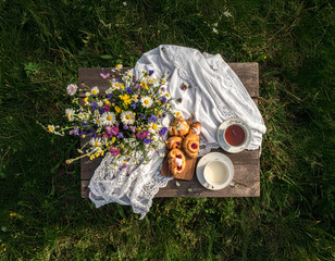 Top-Down View of Wooden Outdoor Table with Lace Cloth and Wildflower Bouquet