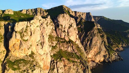 Dramatic coastal cliffs with lush green vegetation under clear blue skies