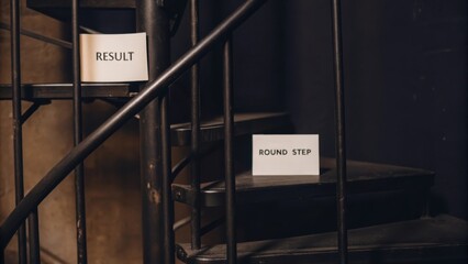 Signs on Spiral Staircase Indicating Result and Round Step Directions