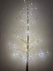 Glowing decorative tree with lights on branches, copy space, New Year concept