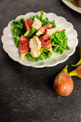 Salad figs, soft cheese, green leaf lettuce tasty snack fresh delicious gourmet food background on the table rustic food top view copy space keto and paleo diet vegetarian food