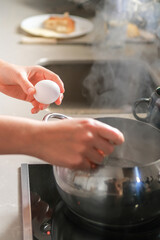 Young woman working remotely from the kitchen, balancing cooking and video call, enjoying mindful morning routine and modern lifestyle. Home office, wellness, healthy habits.