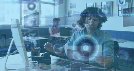 Gesturing African American male interacting with laptop and digital overlays in modern office