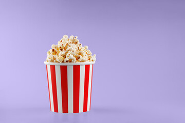 Classic red striped popcorn cardboard cup on Purple, violet background