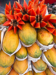 Fresh papayas on market display with cut star-shaped fruits