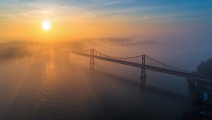 Fototapeta premium Majestic Bridge at Sunrise Through Misty Atmosphere