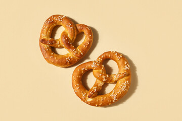 Tasty pretzels on beige background, closeup