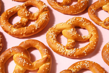 Composition with tasty pretzels on pink background, closeup