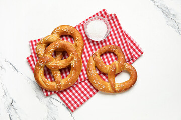Napkin and tasty pretzels on marble background, closeup