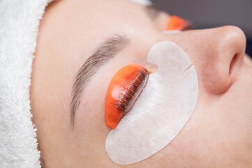 Caucasian woman undergoing eyelash lamination procedure. 